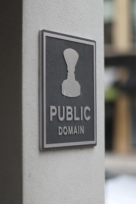 Image of a plaque on a wall with a stamp and the words "PUBLIC DOMAIN"