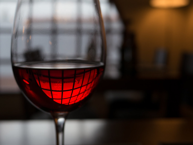 an image with a closeup with a glass of red wine, rest of background scene out of focus due to short depth of field.