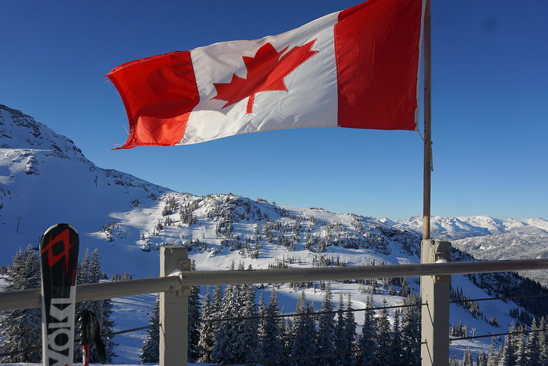 A Canadian Flag flying over the Whistler mountain gondola in winter.