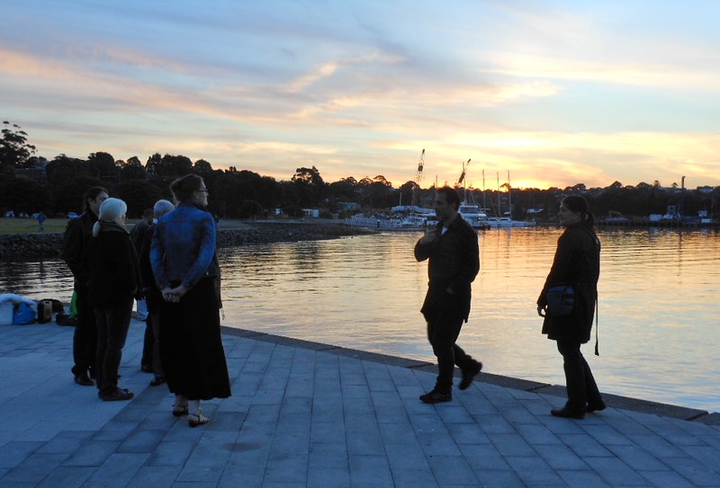 People reflecting during a sunset on a wharf in Sydney, NSW, Australia.