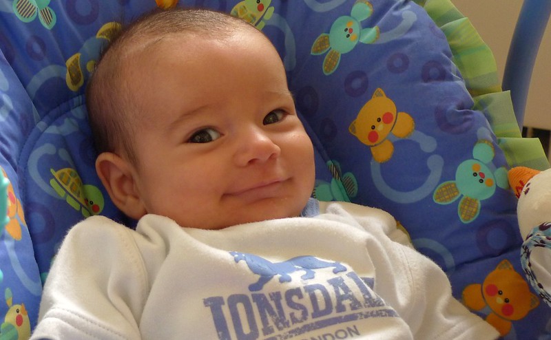 Close-up of a baby with a big smile on their face.