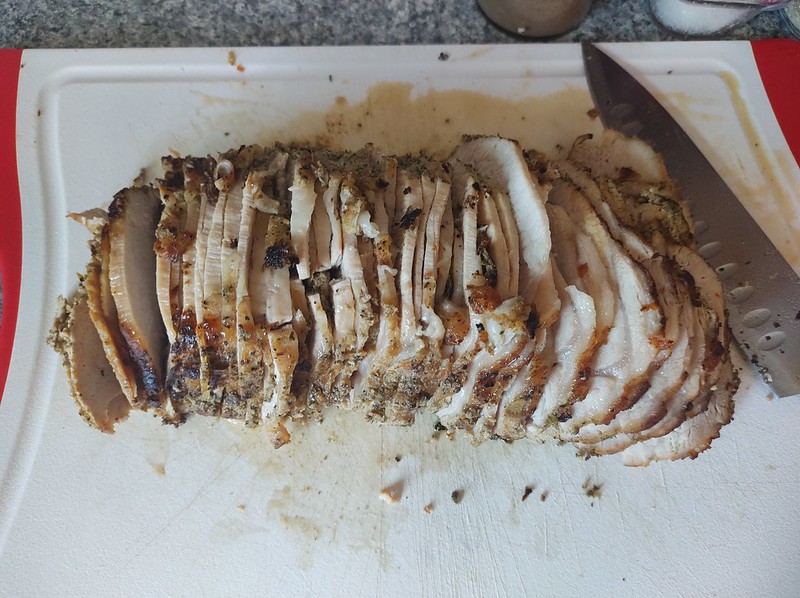 A pork roast sliced on a cutting board, ready to be served.