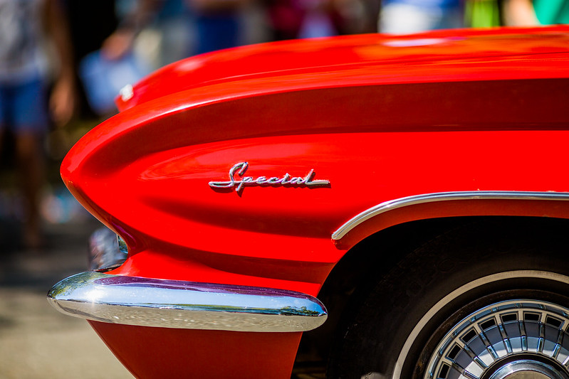 The front left fender with some of the wheel showing of a red classic car (appears to be 50s or 60s) with the word Special in cursive metal decoration.